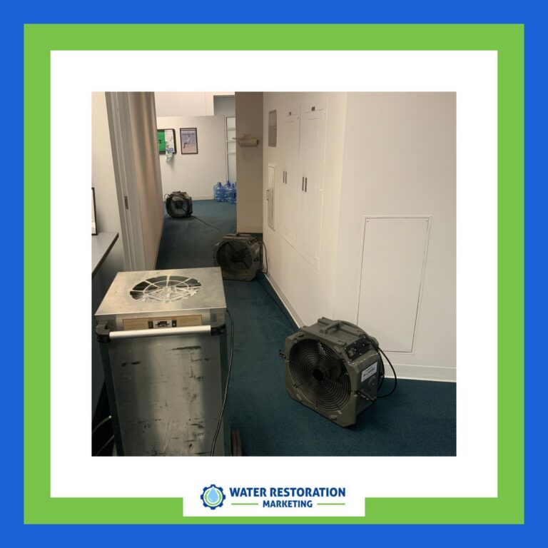 Fans drying water-damaged hallway