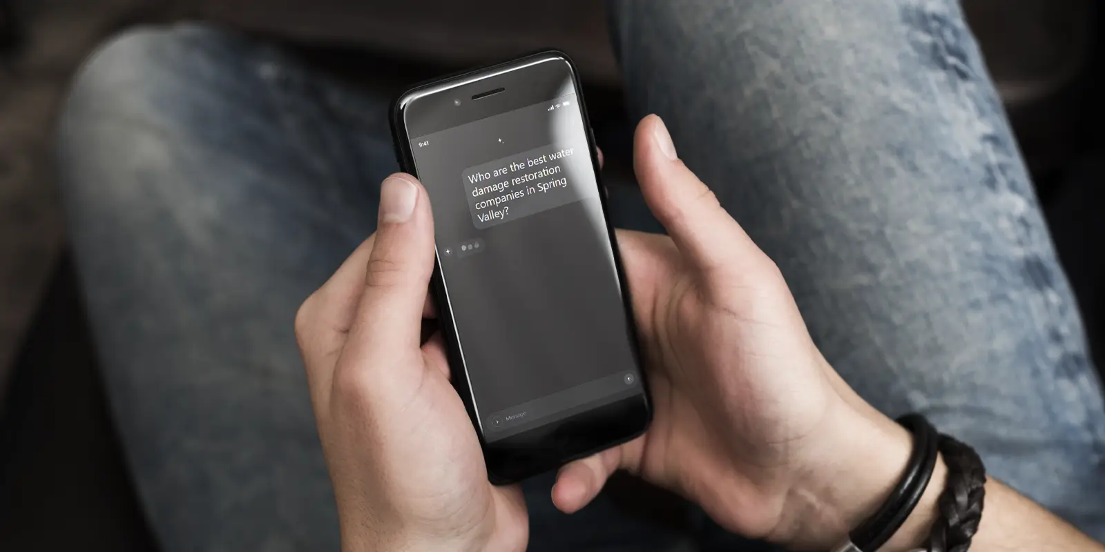 Person chatting with AI on their phone, showing the result of AI SEO services for damage restoration companies